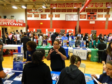 A representative for the Benjamin Franklin Institute of Technology (front, center) talks with a prospective applicant at the annual College Fair at Watertown High School on Oct. 9, 2014. 