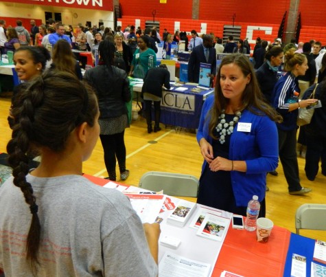 Jill Tyburski from Bunker Hill Community College talks with a prospective applicant at the College Fair at Watertown High School on Oct. 9, 2014. 
