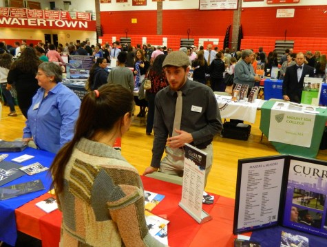 Jake Mattleman, an assistant director of admissions at Clark University, talks with a prospective applicant at the annual College Fair at Watertown High School on Oct. 9, 2014. 