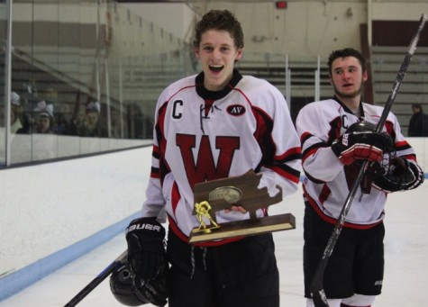 Nick Giordano gets his turn with the Division 3 North trophy as senior classmate Austin Farry looks on after Watertown High's 2-1 victory over Bedford at Chelmsford Arena in Billerica on Friday, March 6, 2015. 
