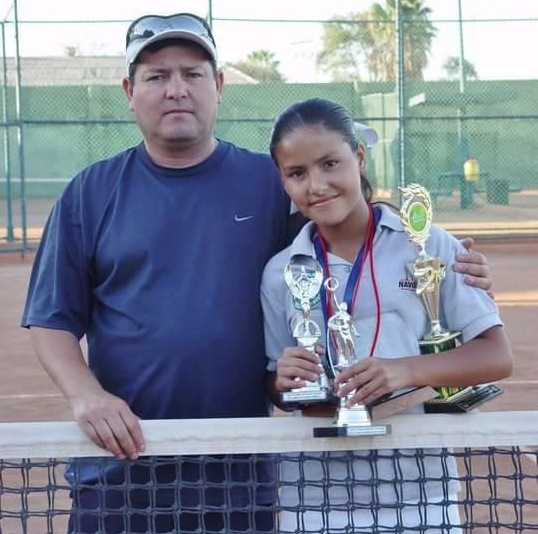 New Watertown High tennis player Lilian Marr Calderon poses with her father and some of her trophies.