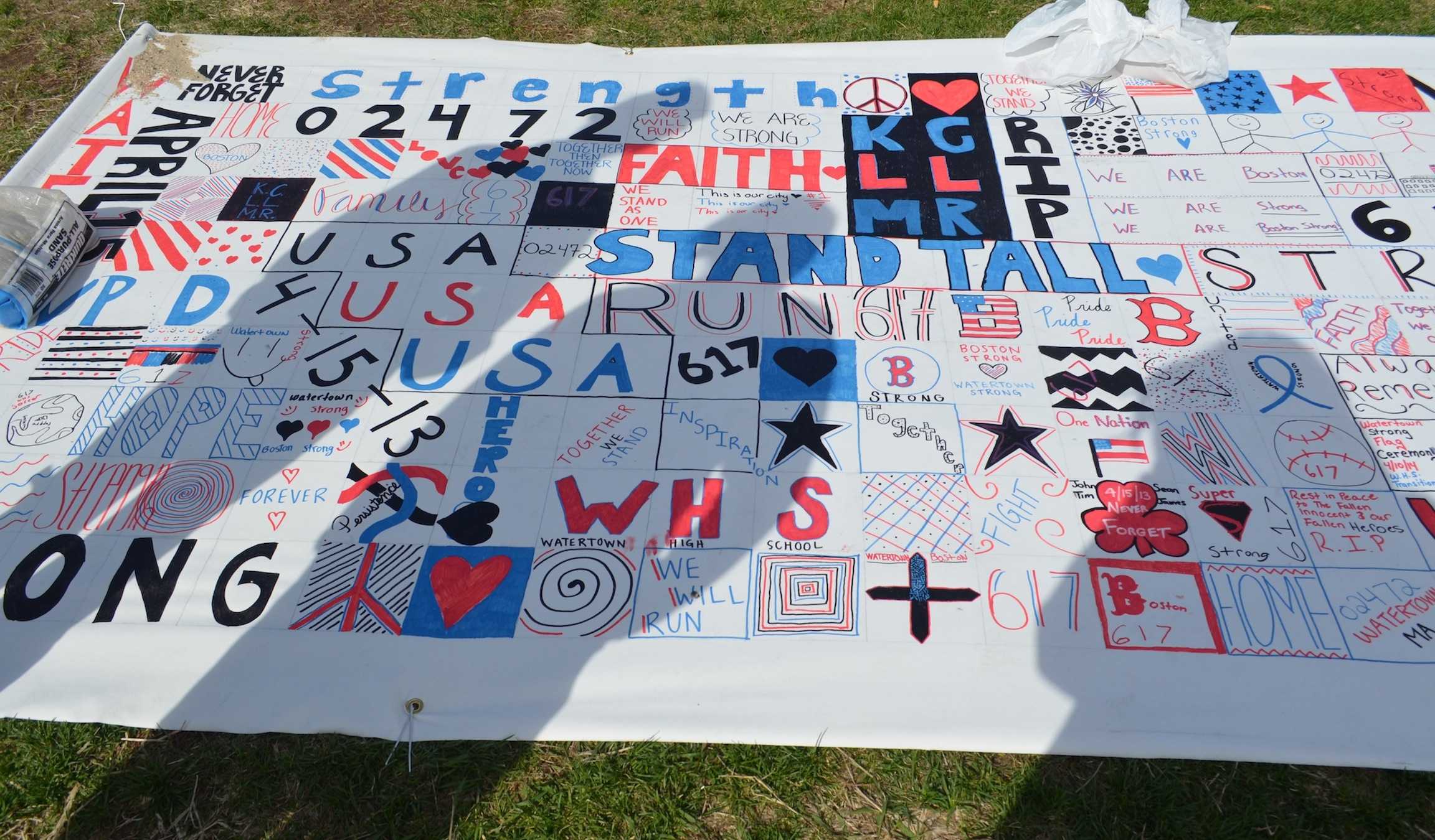 Prayer canvases from around the country, including this one decorated by Watertown High School students, cover the Boston Common during Patriots Day weekend. The canvases were made in a response to the 2013 Marathon bombings.