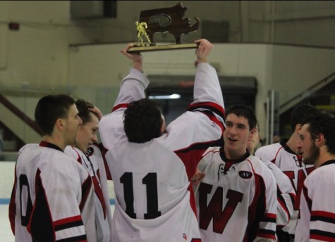 Senior captain Brendan Berkeley (11) gets his turn with the Division 3 North trophy after Watertown's 2-1 victory over Bedford at Chelmsford Arena in Billerica on Friday, March 6, 2015. 
