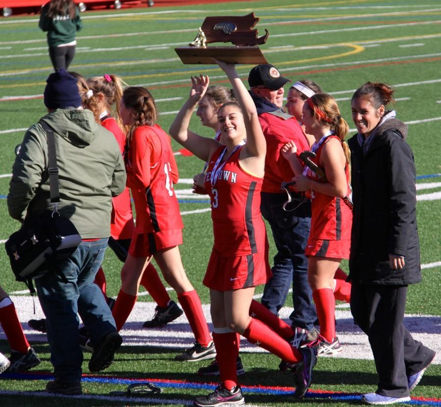 Senior Michaela Antonellis holds the trophy as the Watertown field hockey team celebrates after winning the MIAA Division 2 state championship on Saturday, Nov. 21, 2015, in Worcester. The Raiders beat Auburn, 6-0, for their seventh straight MIAA state championship while extending their national-record unbeaten streak to 160 games.