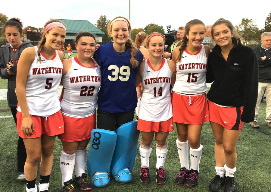 Members of the Watertown High field hockey team pose at Victory Field in Watertown, Mass., after the Raiders’ record-setting 154th game without a loss Oct. 21, 2015. 