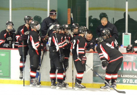 Watertown High skaters gather near coach Mike Hayes during a stoppage in play Thursday night. The Raiders opened defense of their state title with a 3-0 win over Northeast Regional in MIAA Division 3 North action.