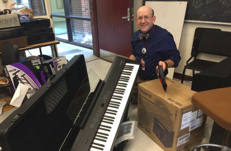 Dan Wulf -- who teaches math, music, and chorus at Watertown High School -- poses with some of the instruments purchased with the recent grant from Music Drives Us.