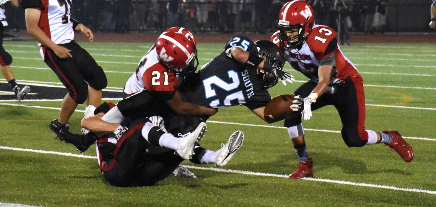 Mange Camara (21) and Yoseph Hamad (13) take care of a Panthers ball carrier as Watertown (2-0) won on the road, defeating Plymouth South, 48-29, on Friday, Sept. 15, 2017.