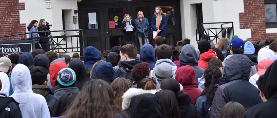 Seren Theriault (left), Olivia DeKoster (center), and Alyssa Carroll speak to students, faculty, and staff at Watertown High School during the student-led walkout March 21, 2018, to protest gun violence.