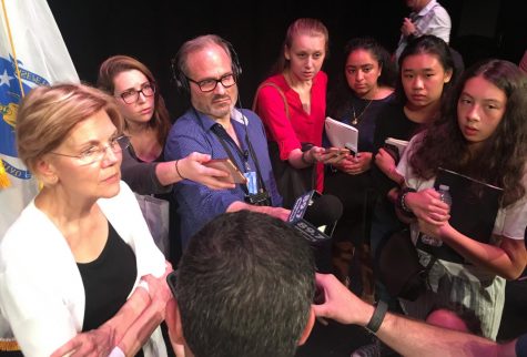 Senator Elizabeth Warren left is surrounded by reporters after a talk at Woburn High School on Aug. 8, 2018.