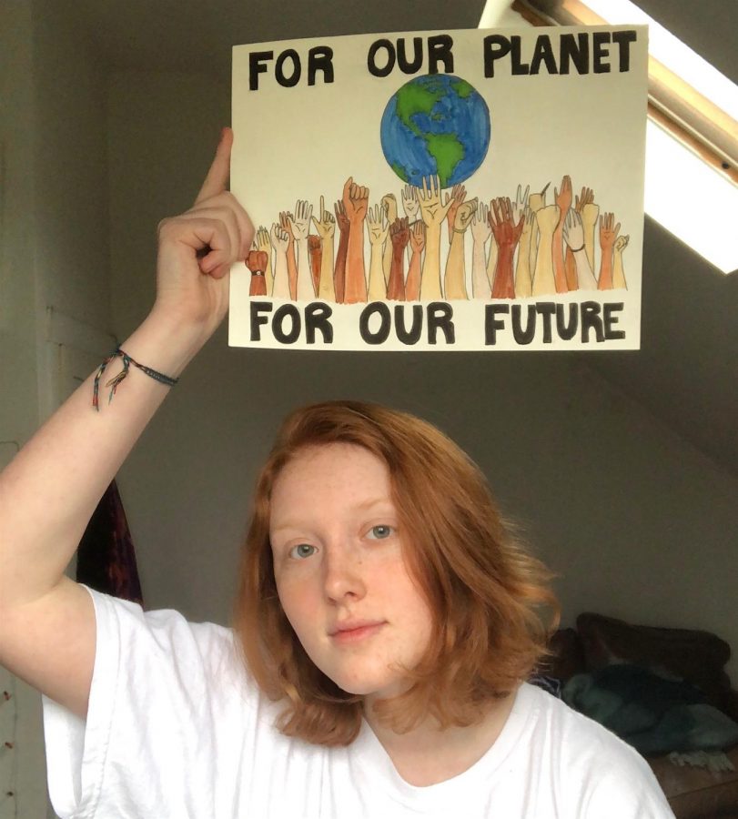 Lana Taffel of the Watertown High School Strike Circle holds one of the signs made for the Earth Day events beginning April 22, 2020.