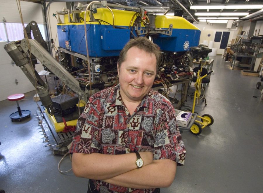 Chris German, a senior scientist at Woods Hole Oceanographic Institution (WHOI), stands in front of Jason, a remotely operated vehicle used for deep-sea exploration.