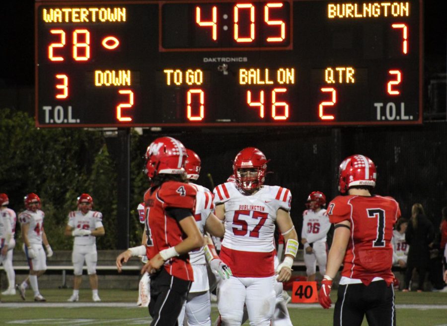 Raiders quarterback Johnny Cacace sneaks a peek at the Victory Field scoreboard during Watertown High Schools 42-7 win over Burlington on Friday, Sept. 30, 2022.